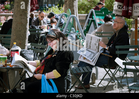 Besucher zum Bryant Park in New York nutzen Sie kostenlose Zeitungen im Lesesaal der Bryant Park Bereich des Parks Stockfoto