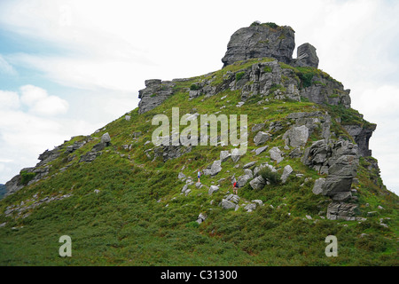 Zwei Wanderer Klettern Castle Rock auf der South West Coast Path in der Nähe von das Tal der Felsen in North Devon England UK Stockfoto