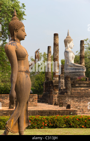 Statuen des Buddha zu Fuß und sitzenden Buddha am Wat Sa Si, Teil des Sukothai Historical Park in Thailand Stockfoto