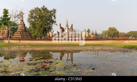 Große sitzende Buddha und Tempel-Ruinen des Wat Mahathat mit Reflexion in Lilly Teich im historischen Park Sukothai in Thailand Stockfoto