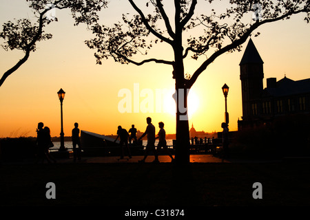 Passanten im Battery Park, Downtown Manhattan, vor dem Hafen von New York (New York City) Stockfoto