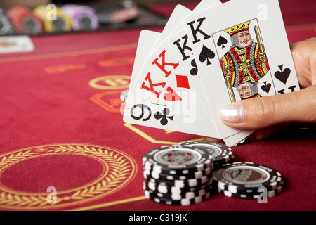 Bild von fünf Spielkarten in Händen mit schwarze Chips in der Nähe von Stockfoto