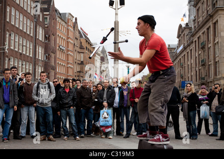 Eine Straße Entertainer hat seine Tat für eine Menge von Touristen, die vor Madame Tussauds Wachsfigurenkabinett, Amsterdam gesammelt haben Stockfoto