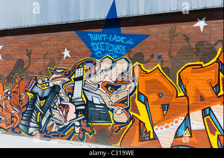 Kunstvolle Graffitis auf einen langen Stein Wand in München-Giesing zeigen einen bunten Tag und verschiedene Elemente der Hip-Hop-Kultur, Deutschland Stockfoto