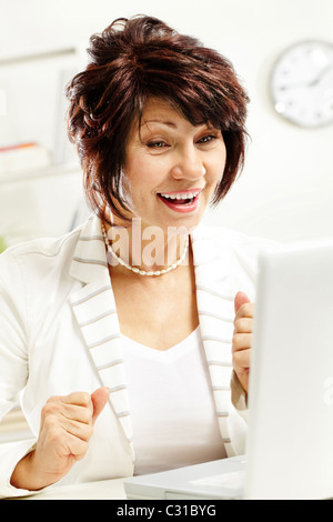 Porträt der erstaunt mittleren Alters weiblichen Blick auf Laptop-display Stockfoto