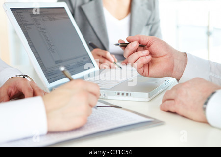 Hand des Chef zeigt auf Laptop-Bildschirm bei briefing Stockfoto