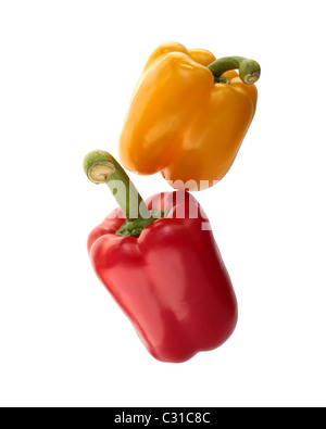Gelbe und rote Paprika gestapelt. Isoliert auf weißem Hintergrund. Stockfoto