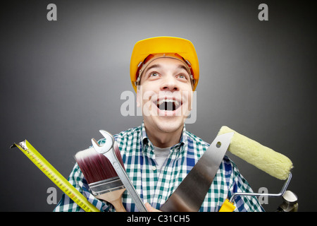 Porträt von glücklich Handwerker mit verschiedenen Werkzeugen in Händen Stockfoto