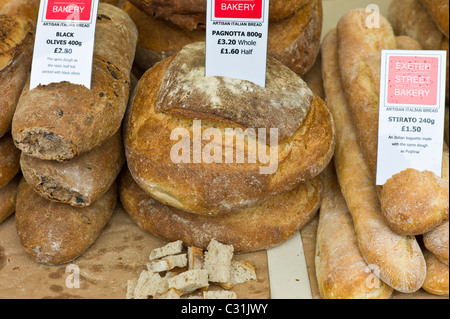 Artisan Italienisch Brot Pagnotta, schwarzen Oliven und Stirato zum Verkauf an Exeter Street Bakery Stall im Bauernmarkt Stockfoto