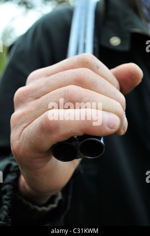 JÄGER SEIN FALTENDE AKTIEN GEWEHR ÜBER DER SCHULTER TRAGEN Stockfoto