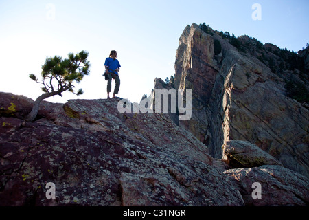 Ein junger Erwachsener steht triumphierend auf eine 500 ft Multi Pitch Trad Kletterroute in Colorado. Stockfoto