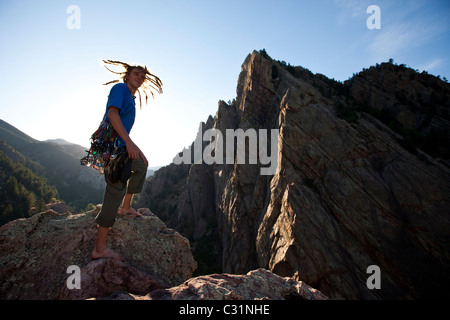 Ein junger Erwachsener steht triumphierend auf eine 500 ft Multi Pitch Trad Kletterroute in Colorado. Stockfoto