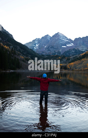 Ein junger Mann Stand in einem See mit seinen Armen öffnen umfassenden Natur. Stockfoto