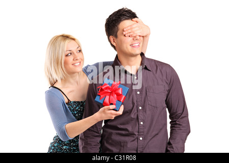 Eine romantische Frau ihres Freundes Augen bedecken, überraschen ihn mit einem Geschenk, isoliert auf weiss Stockfoto