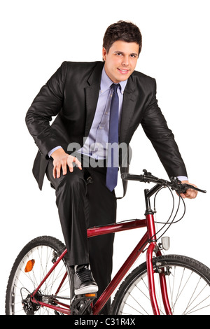 Ein junger Geschäftsmann posiert auf einem Fahrrad Stockfoto