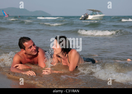 URLAUB PAAR LIEGEN IM WASSER, AM STRAND IM HOTEL CORAL, BANG SAPHAN, PRACHUAP KHIRI KHAN, THAILANDE, ASIEN Stockfoto