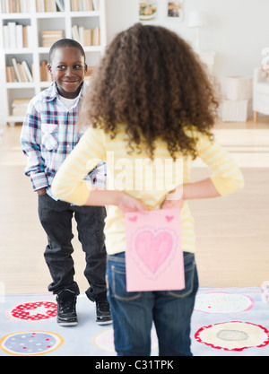 Mädchen halten Valentine Karte hinter ihrem Rücken Stockfoto