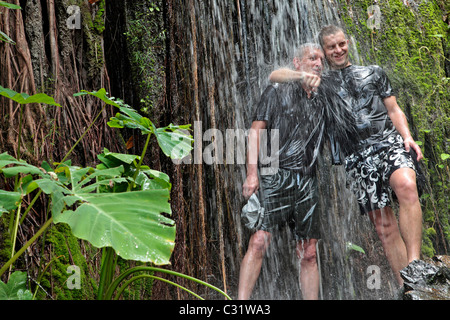 "COOLING OFF" UNTER EINEM WASSERFALL, TREKKING IM DSCHUNGEL, NATURSCHUTZGEBIET IN DER REGION VON BANG SAPHAN, THAILAND, ASIEN Stockfoto