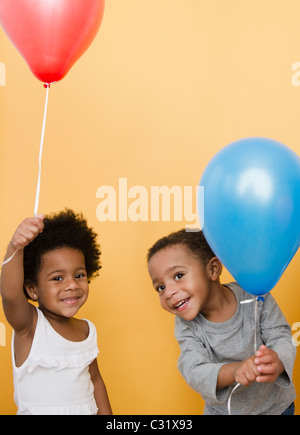 Schwarze Kinder, die mit Helium-Ballons Stockfoto