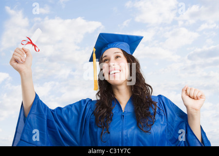 Gemischte Rassen Trägerin Graduierung Mütze und Mantel mit Diplom Stockfoto