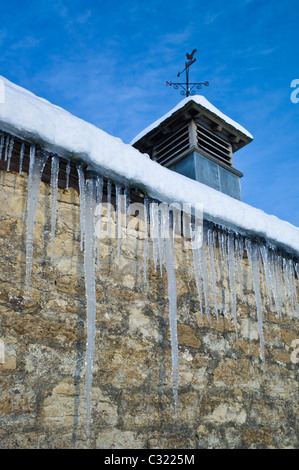 Wetterfahne und Eiszapfen auf einer Scheune in Cotswolds Stockfoto