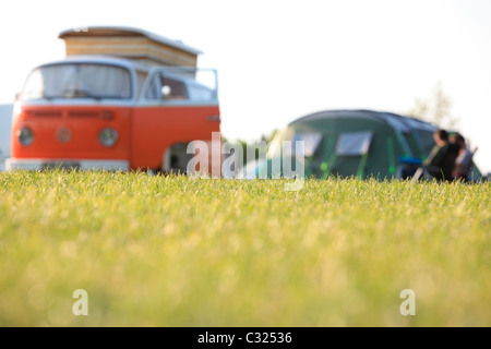 Paar sitzt mit Zelt und Volkswagen W Wohnmobil in einem Feld in das Morgenlicht camping in East Sussex Stockfoto