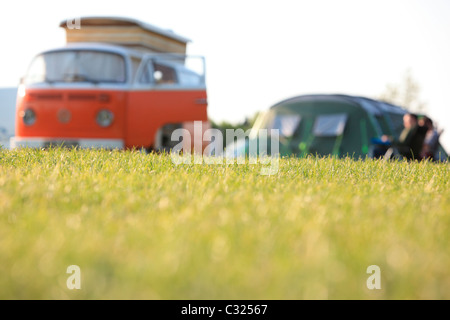 Paar sitzt mit Zelt und Volkswagen W Wohnmobil in einem Feld in das Morgenlicht camping in East Sussex Stockfoto