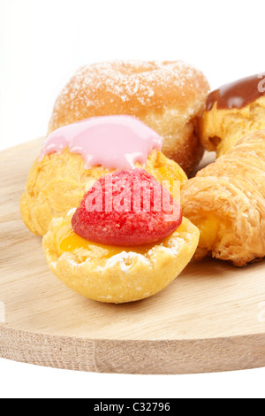 Verschiedene Tee Kuchen auf einem hölzernen Schneiden an Bord auf weißem Hintergrund. Stockfoto