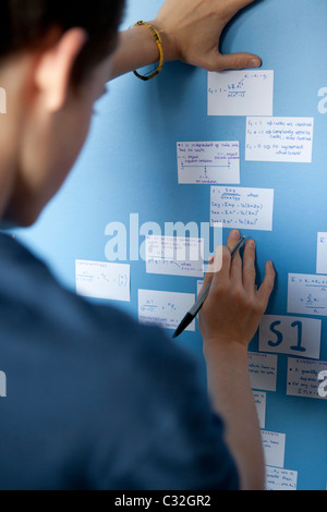 Teenager, die Überarbeitung für Mathematik A-Level mit Überarbeitung Karten stecken auf seiner Schlafzimmerwand. Stockfoto