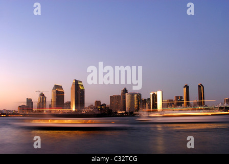 Zwei Boote fahren Sie unter der Skyline von San Diego in der Dämmerung wie von Coronado Island, Kalifornien zu sehen. Stockfoto