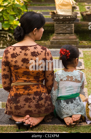 Mutter und Tochter kniet am Saraswati Tempel, Ubud, Bali, Indonesien Stockfoto