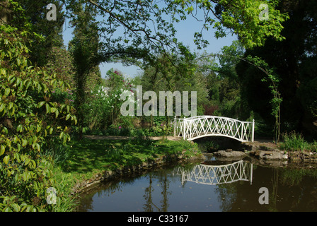 Ein weißes Gusseisen-Brücke in das Waldgebiet der Schweizergarten, Old Warden, Bedfordshire, UK Stockfoto