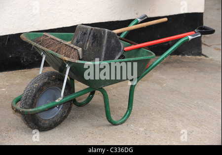 Eine Schubkarre und Werkzeuge auf einem beständigen Yard Stockfoto