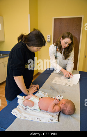 Krankenschwester hinauf über Einzelheiten der Versorgung mit neuen Mutter für eine Woche altes Baby ersten Besuch beim Kinderarzt für Check Stockfoto