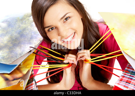 Porträt von fröhliches Mädchen mit bunten Papiertüten Blick in die Kamera Lächeln Stockfoto