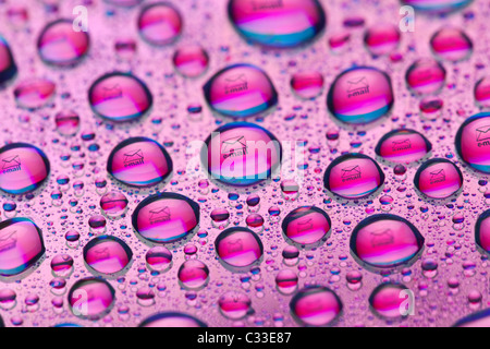 Briefumschlag-Symbol spiegelt sich in den Wassertropfen. Nahaufnahme von Wassertropfen platziert auf einer DVD Stockfoto