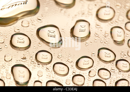 Briefumschlag-Symbol spiegelt sich in den Wassertropfen. Nahaufnahme von Wassertropfen platziert auf einer DVD Stockfoto