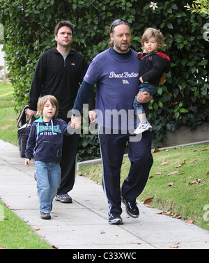 Russell Crowe, trägt ein T-shirt Großbritannien hält die Hand seines Sohnes Charlie, 4, und Sohn Tennyson, 2, wie sie führt Stockfoto