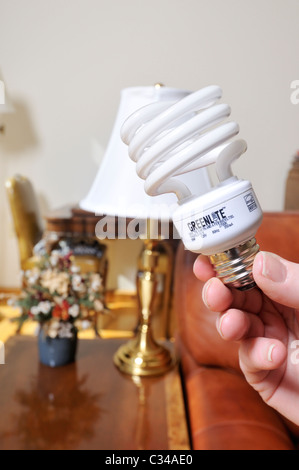 Ändern die Glühbirnen in eine Lampe aus einer Glühbirne in ein energiesparender CFL Lampe im Zimmer des Hauses. Stockfoto