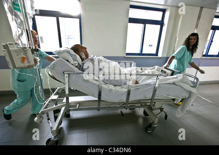 Zwei Krankenschwestern bewegen Bett des Patienten in einem Krankenhaus Stockfoto