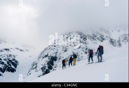 Eine Gruppe von Skitourengeher Klettern auf einem Berghang in Lyngen Alpen, Norwegen Stockfoto