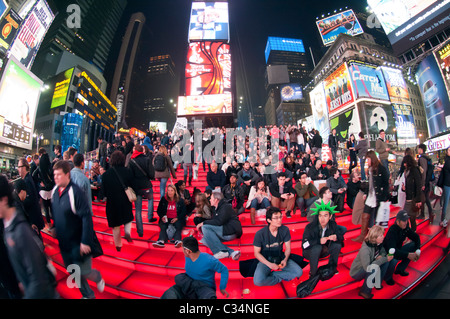 Menschen entspannen Sie sich auf der roten Treppe hinter der TKTS Stand am Times Square in New York Stockfoto