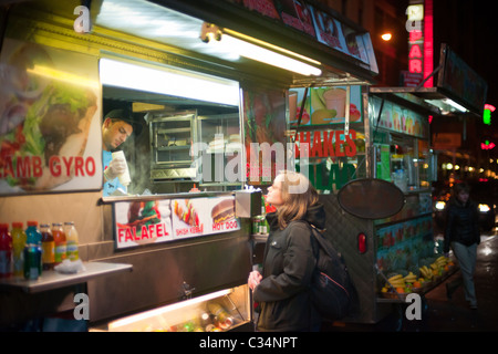 Abendessen wartet darauf, dass ihre Bestellung von nahöstlichen street Food auf dem Times Square in New York Stockfoto