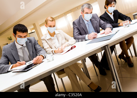 Porträt der Gruppe von Geschäftspartnern in Schutzmasken während der Arbeit Stockfoto