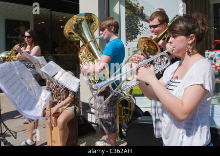 Winchester City, High Street, Gruppe von Schulkindern, jungen & Mädchen, Jugendliche Band busk oder spielen für wohltätige Zwecke spenden Stockfoto