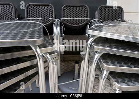 Stühle und Tische gestapelt vor einer geschlossenen Cafébar Stockfoto