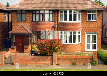 Doppelhaushälfte bay Windows 1930 Ipswich Suffolk England Mann Person im Haus lächelnd Stockfoto