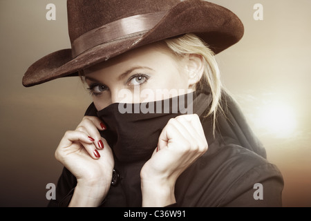 Kriminelle Frau mit Cowboy-Hut bei heißen Sonnenuntergang. Kreative Farben für Film-Effekt hinzugefügt Stockfoto