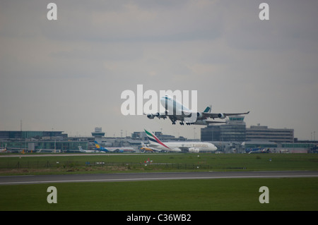 Cathay Pacific Fracht startet vom Flughafen Manchester entfernt, in der Ferne auf dem Vorfeld können sein ein Emirates Airbus A380 zu sehen Stockfoto