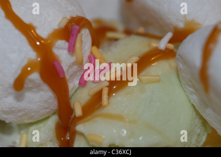 Eis mit Toffee-Sauce und Hunderte und Tausende besprüht. Stockfoto